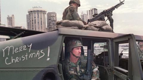 US soldiers man their security position outside the Vatican embassy in Panama City where Panamanian General Manuel Noriega was seeking asylum on 25 December. 1989.