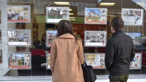 People looking in estate agent window