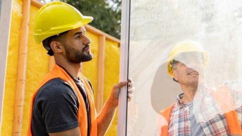 Builders fitting a window