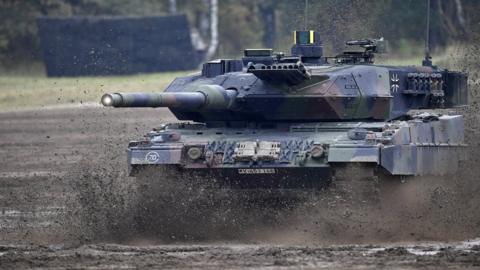 A German leopard tank driving through mud in training exercise