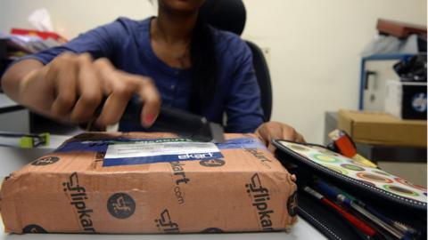 An Indian woman opens a parcel in her office after ordering it from an online shopping website in Mumbai in 2013.