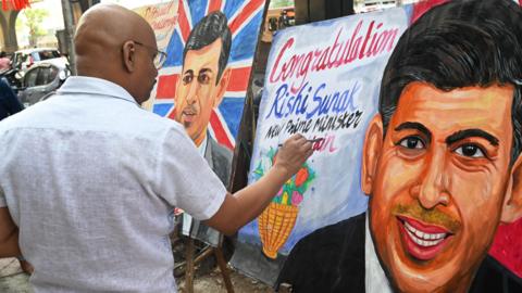 Man in Mumbai paints a picture of Rishi Sunak with a congratulatory message.