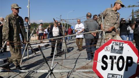 Cypriot soldiers remove a barbered-wire fence at a newly opened checkpoint in Dherinia, Cyprus November 12, 2018.
