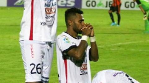 Footballers for Bali United FC assume three different prayer positions