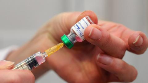 A generic photograph of a vaccine being drawn from a vial into a needle