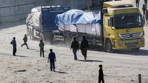 People standing near a truck carrying aid in Rafah