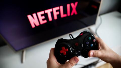 Person using a gaming console with Netflix on screen.