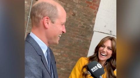 Prince William and Kate Middleton laughing when talking about their favourtite emoji during Radio 1 interview