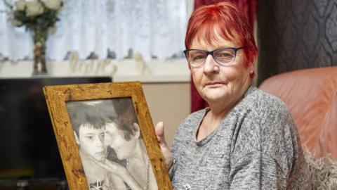 Gwynneth Hunter holding a photo of her daughter and herself together