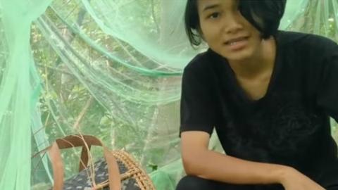 Veveonah sitting in a mosquito net on a platform in a tree