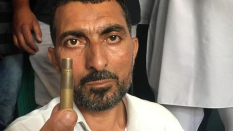 Abdul Rehman Mir holding a bullet case