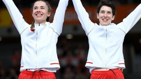 Georgia Holt and Sophie Unwin celebrate their commonwealth Games silver medal on the podium