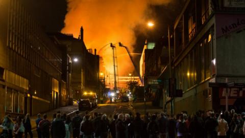 Crowds look on as firefighters tackle the blaze