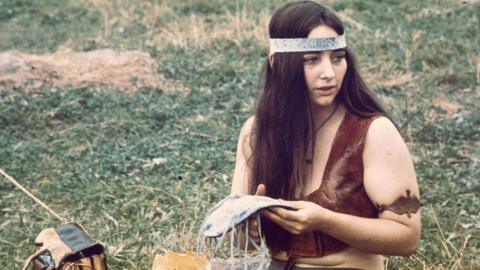 A woman with a leather craft in her hands, near the 'Free Stage' at the Woodstock Music and Arts Fair, Bethel, New York, August 1969
