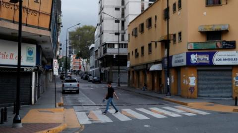 Man walking across empty street in Caracas