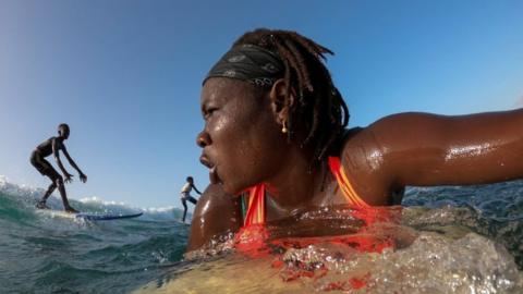 Khadjou Sambe surfs in the ocean