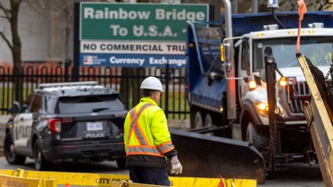 Trucks are positioned to block the entrance to the Rainbow Bridge where the border crossing between the U.S. and Canada has been closed after a vehicle exploded at a checkpoint on a bridge near Niagara Falls, Ont., on 22 November 2023
