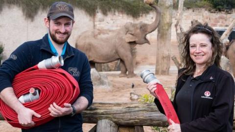 Diane Miller and Chester Zoo employee with fire hoses