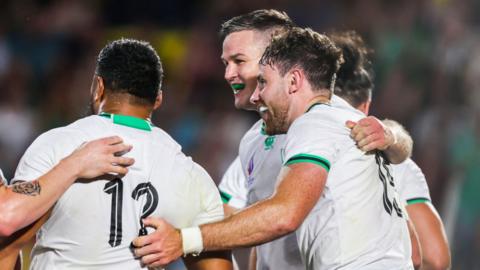 Johnny Sexton celebrates with Hugo Keenan and Bundee Aki after scoring his try