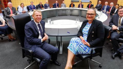 New Zealand cabinet ministers sit around a circular desk in parliament