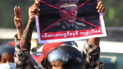 Protesters with image of coup leader