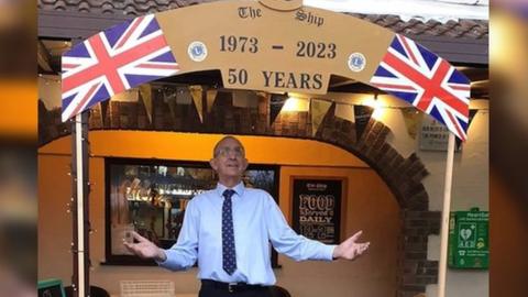 Vic Long stood under a banner marking 50 years of The Ship