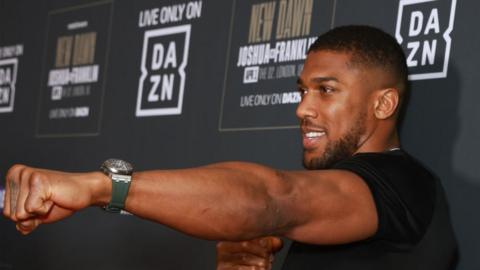 Anthony Joshua holds out his first for the cameras