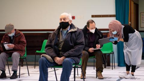 Members of the public wait to receive an injection of the Oxford/AstraZeneca coronavirus vaccine at the Al Abbas Mosque, Birmingham