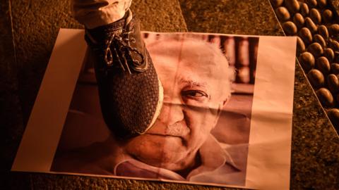 Pro-Erdogan supporter walks on poster picturing US-based preacher Fethullah Gulen during rally at Taksim square in Istanbul on July 18, 2016