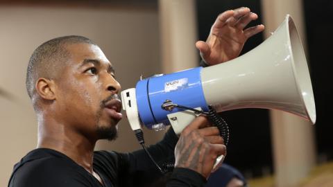 Presnel Kimpembe speaks to PSG fans through a megaphone