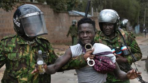 A suspected demonstrator is apprehended by Kenyan police during confrontations between authorities and supporters of the Kenyan opposition during anti-government protests in Nairobi on July 19, 2023.