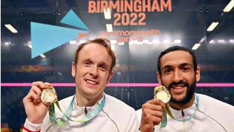 England's Declan James and James Willstrop hold aloft their gold medals from the squash men's doubles