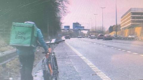 Person walking with bike at side of the M602