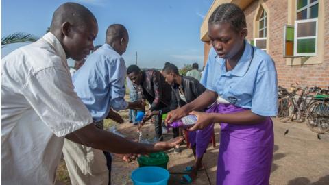 People washing hands outside church