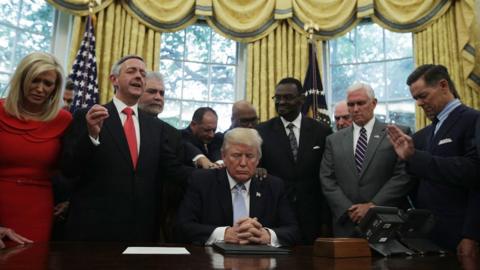 .S. President Donald Trump, Vice President Mike Pence and faith leaders say a prayer during the signing of a proclamation in the Oval Office of the White House September 1, 2017 in Washington, DC