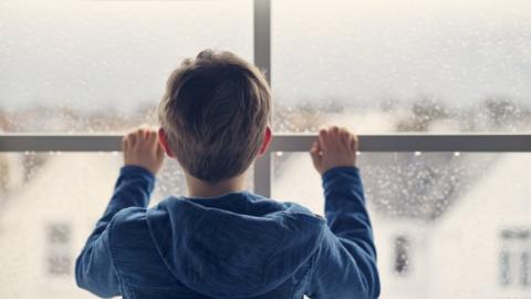 Boy standing by window