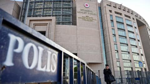 A woman walks in front of the courthouse in Istanbul on December 11, 2019 during the trial of Metin Topuz