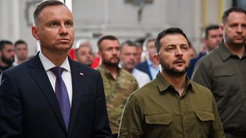 Ukraine's President Volodymyr Zelensky and his Polish counterpart Andrzej Duda (L) attend service in Lutsk cathedral, 9 Jul 23