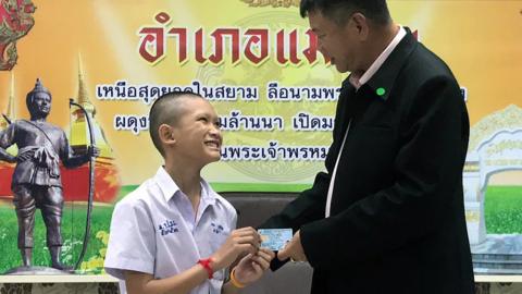 Mongkol Boonpiam (L) as he receives Thai citizen ID card from Mae Sai District Chief Somsak Kanakham (R)