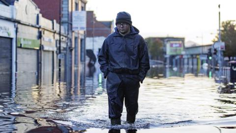 A man walks through flood waters in Downpatrick