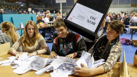 Staff count ballot papers at the Glasgow count centre at the Emirates Arena