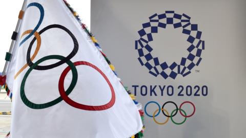 An Olympic Flag pictured next to the Tokyo 2020 logo