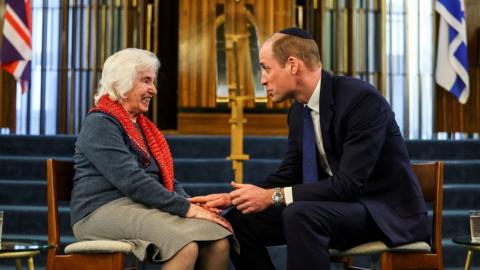 An image showing Prince William and Holocaust survivor Renee Salt, seated and talking in a synagogue