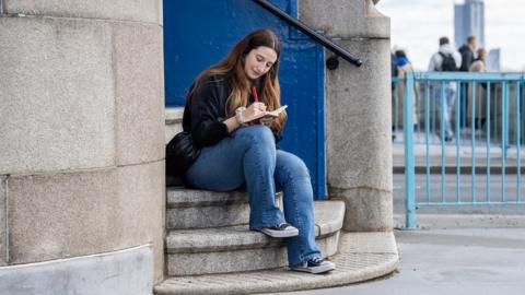 Poet writing on bridge steps