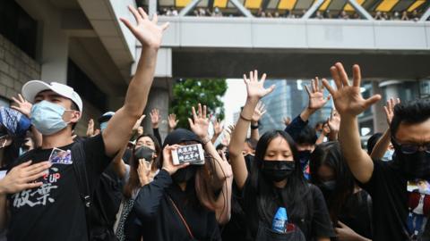 Masked protesters gesture to symbolise their five demands outside the High Court premises.
