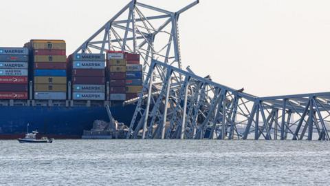 Francis Scott Key Bridge wreckage lies across the Dali cargo ship in Baltimore