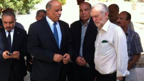 Maher Taher is pictured, centre, no tie, over Jeremy Corbyn's right shoulder at a Tunisian cemetery