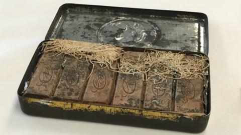 An antique tin with bars of chocolate