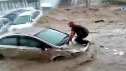 Man on car bonnet in flood