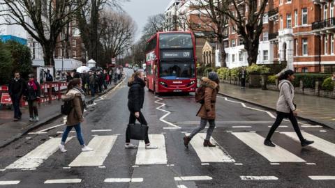 Beatles' fans cross Abbey Road zebra crossing